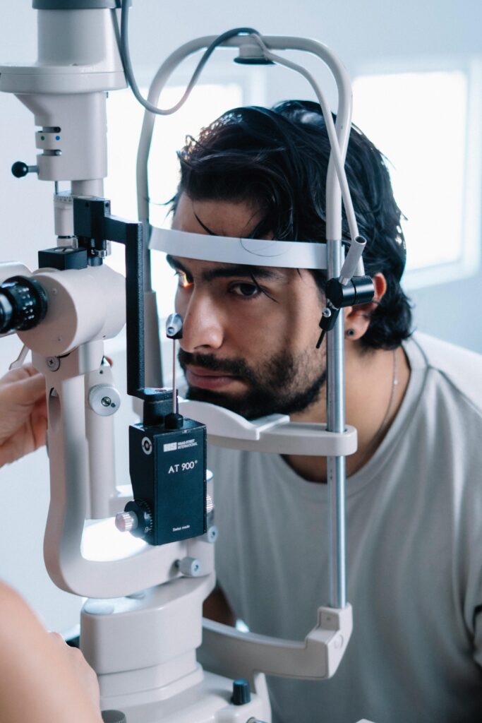 A man is examined using a slit lamp during an eye check-up at a clinic.